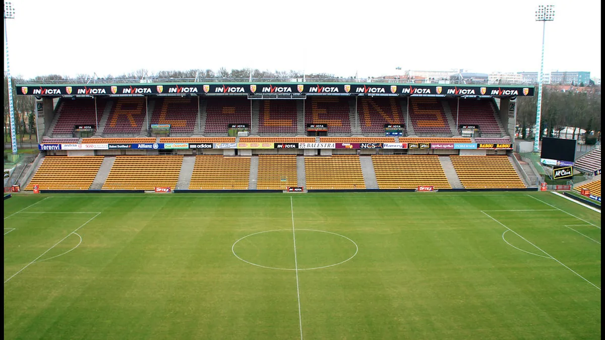 Stadio di calcio vuoto visto dalla tribuna, con il campo illuminato